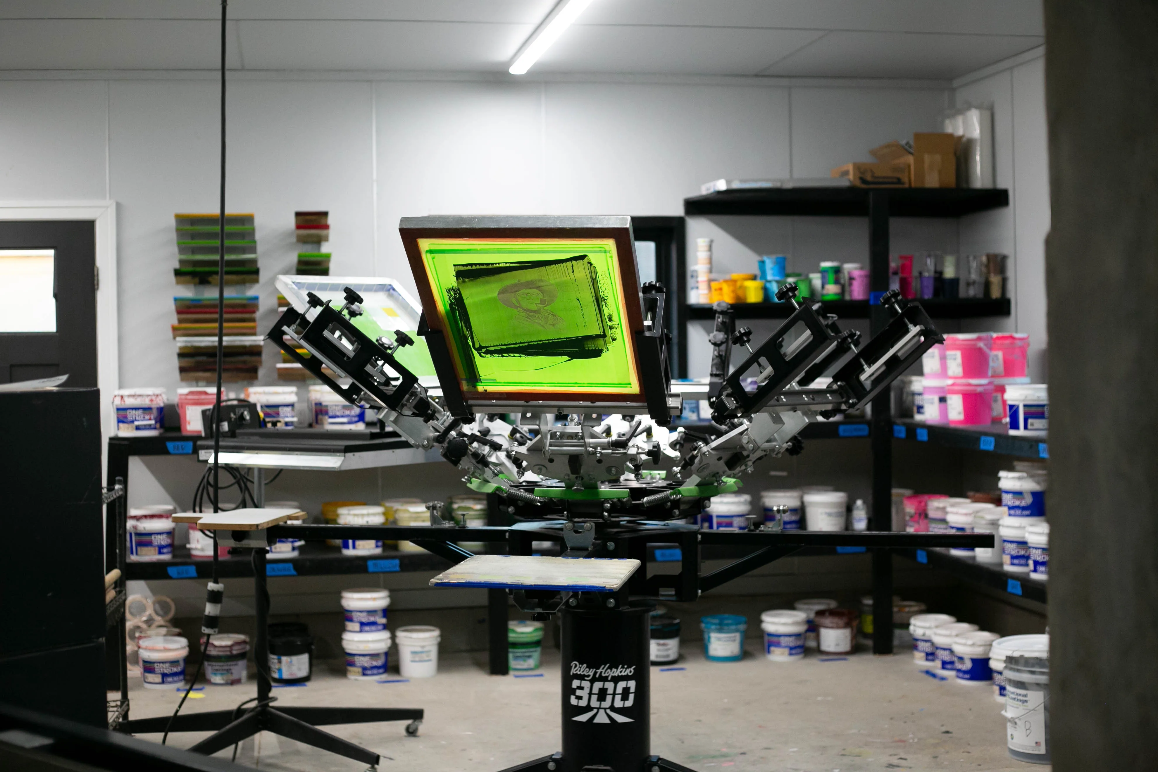 Manual screen printing press mid-print